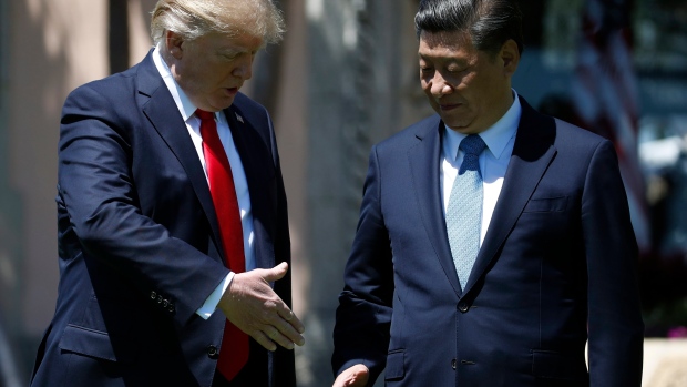 President Donald Trump and Chinese President Xi Jinping reach to shake hands at Mar-a-Lago, April 7.