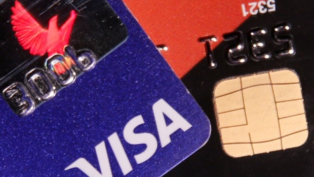 A VISA credit card is pictured next to a computer chip on a bank card in this photo illustration