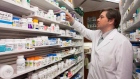 A pharmacist checks a bottle on a shelf at his pharmacy in Quebec City. pharmaceuticals
