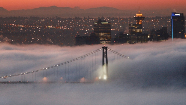 Morning fog blankets the Lions Gate Bridge and parts of the downtown just before dawn in Vancouver