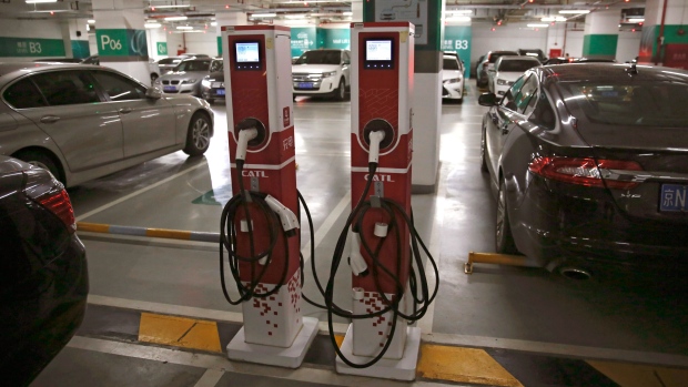 Gasoline vehicles are parked around the charging pole for electric vehicles at a shopping mall