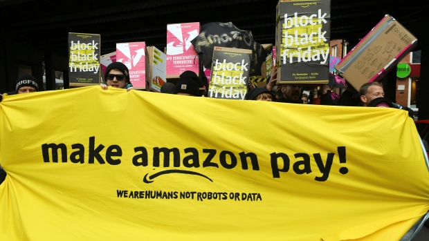 Demonstrators hold a banner and posters during a rally against the online retailer Amazon in Berlin
