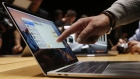 A guest points to a new MacBook Pro during an Apple media event in Cupertino, Calif.