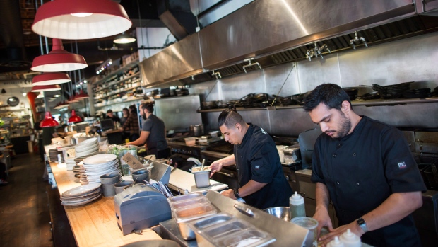 Line cooks Ishaan Kohli, right, and Abrahan Ruiz, second right, work in the kitchen at Edible Canada