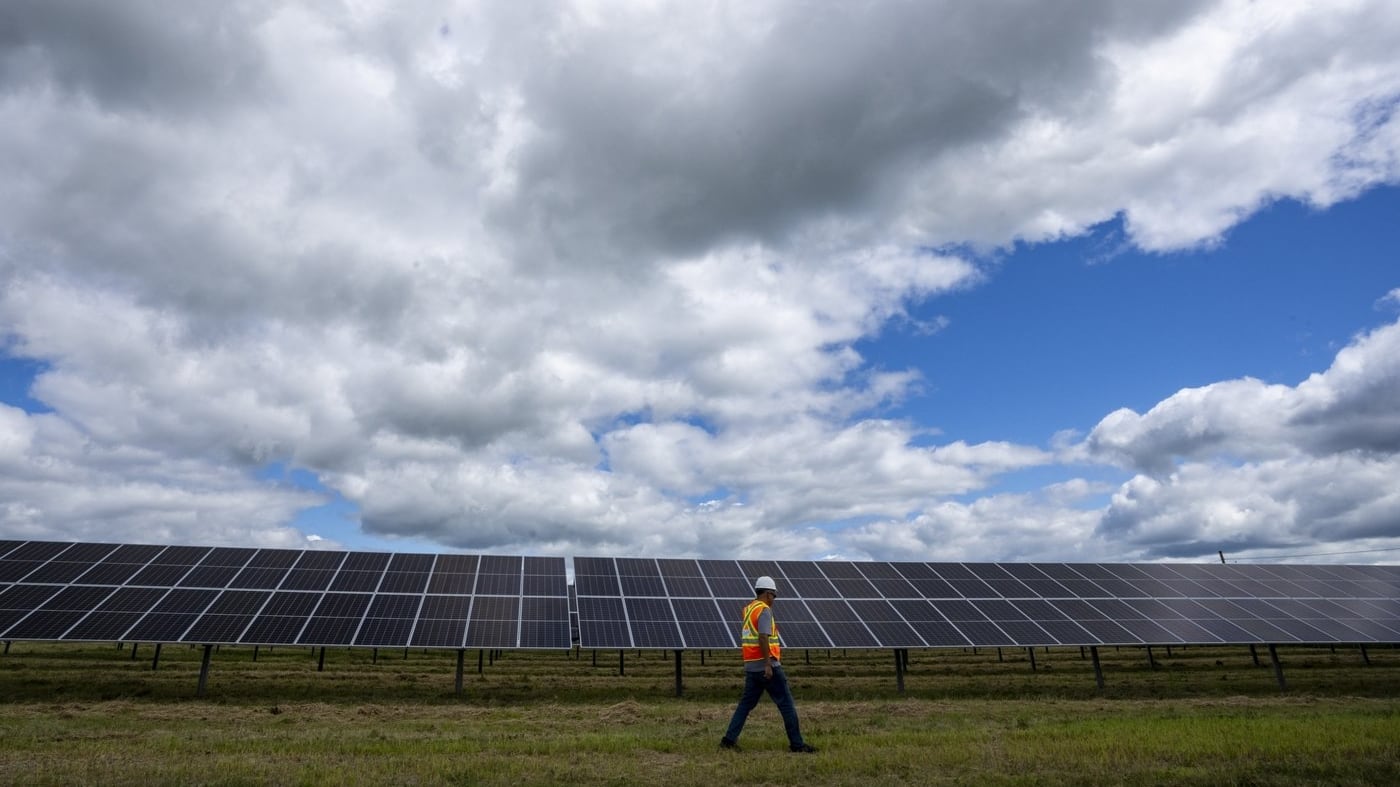 A Hydro-Québec employee walks past monofacial solar panels installed on the 5.6 hectares at the Robert-A.-Boyd Solar Power Plant in Varennes, Que., on Monday, July 21, 2025. THE CANADIAN PRESS/Christinne Muschi