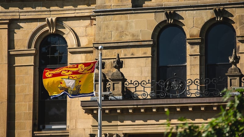 The New Brunswick flag flies in front of the legislative assembly building, home of the provincial parliament, in Fredericton, Saturday, July 26, 2025. THE CANADIAN PRESS/Giordano Ciampini
