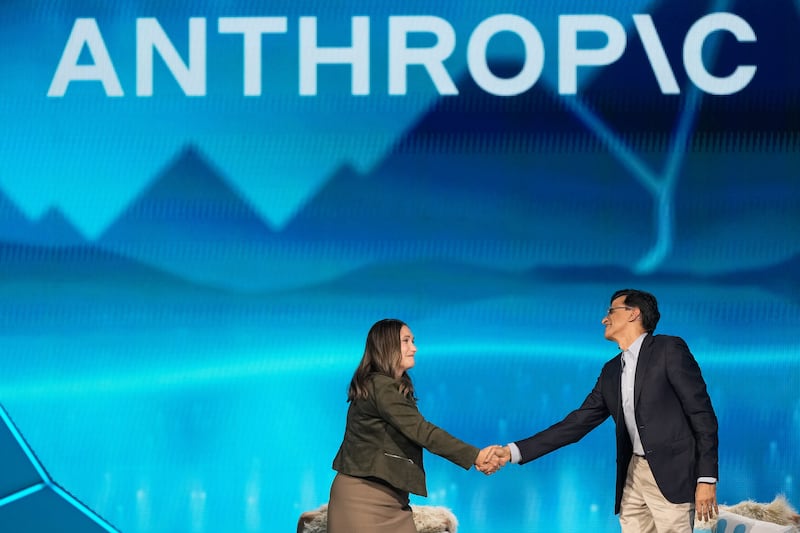 Anthropic co-founder and president Daniela Amodei, left, shakes hands with Snowflake CEO Sridhar Ramaswamy during the keynote presentaton at Snowflake Summit 26 in San Francisco on June 1, 2026. (Jeff Chiu / AP Photo)