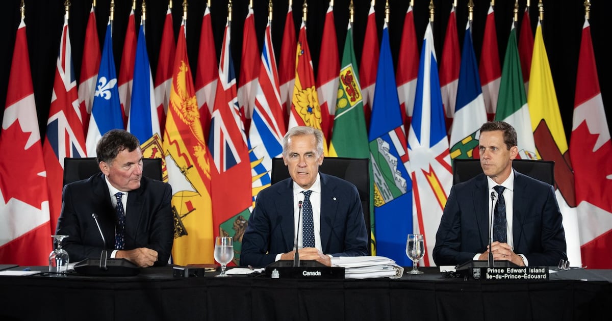 Prime Minister Mark Carney, centre, addresses Canada's premiers with Canada-U.S. Trade Minister Dominic LeBlanc, left, and Prince Edward Island Premier Rob Lantz during first ministers meetings in Charlottetown on Thursday, July 23, 2026. THE CANADIAN PRESS/Darren Calabrese
