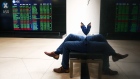 <p>A man looks at his phone at the Australian Securities Exchange in Sydney, Australia.</p>