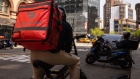 <p>A delivery worker carries a DoorDash bag in New York.</p>