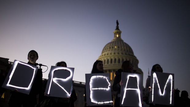 Demonstrators hold illuminated signs during a rally supporting the Deferred Action for Childhood Arrivals program (DACA), or the Dream Act, outside the U.S. Capitol building in Washington, D.C., U.S., on Thursday, Jan. 18, 2018. The House passed a spending bill Thursday to avoid a U.S. government shutdown, but Senate Democrats say they have the votes to block the measure in a bid to force Republicans and President Donald Trump to include protection for young immigrants. Photographer: Zach Gibson/Bloomberg  